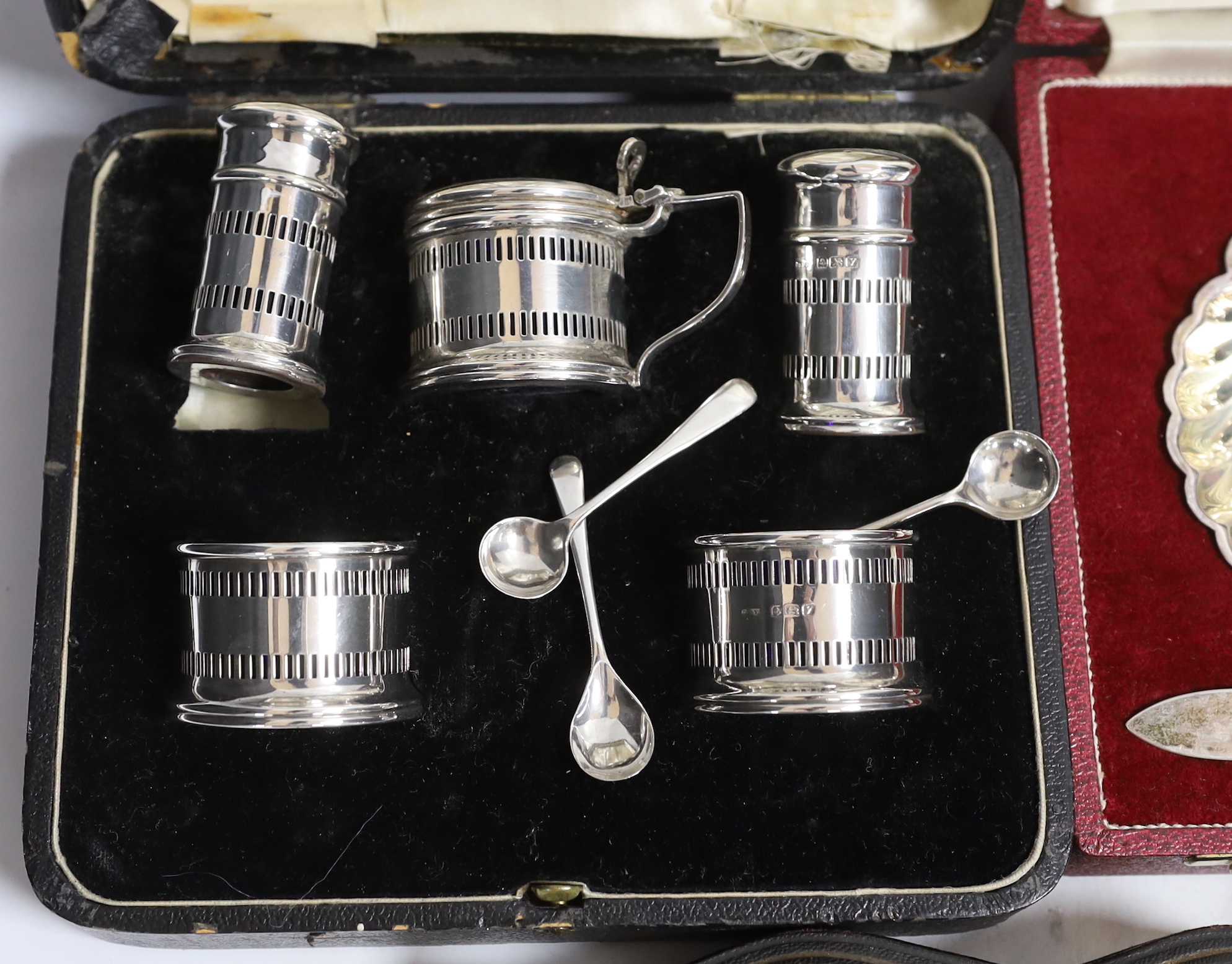 Two modern silver cased shell and butter knife sets, a cased silver five piece condiment set, a cased set of six silver teaspoons with tongs, one other cased silver butter shell and knife and a cased set of plated teaspo